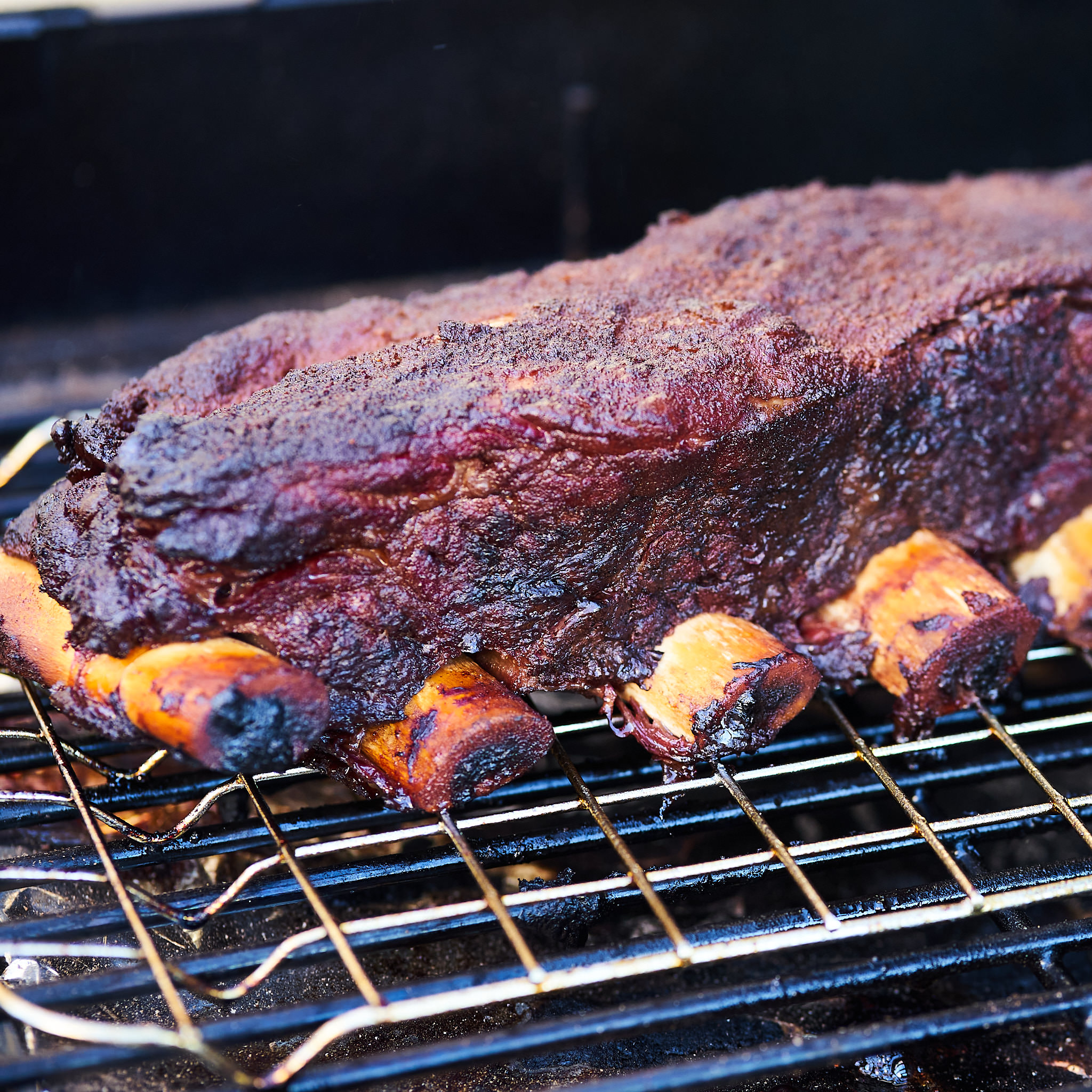 Shortribs mit herrlicher Kruste auf dem Grillgitter Seitenansicht